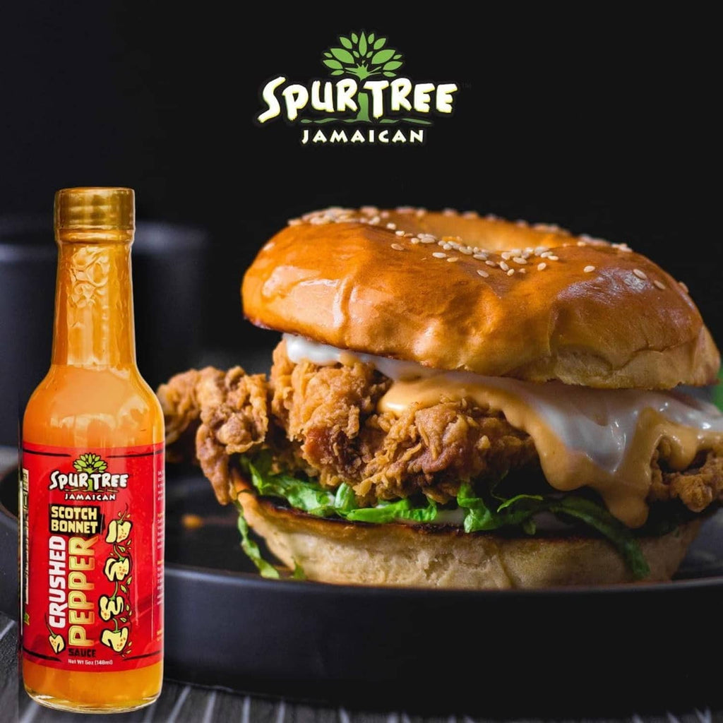 Spur Tree Jamaican scotch bonnet pepper sauce bottle beside sandwich with melted cheese