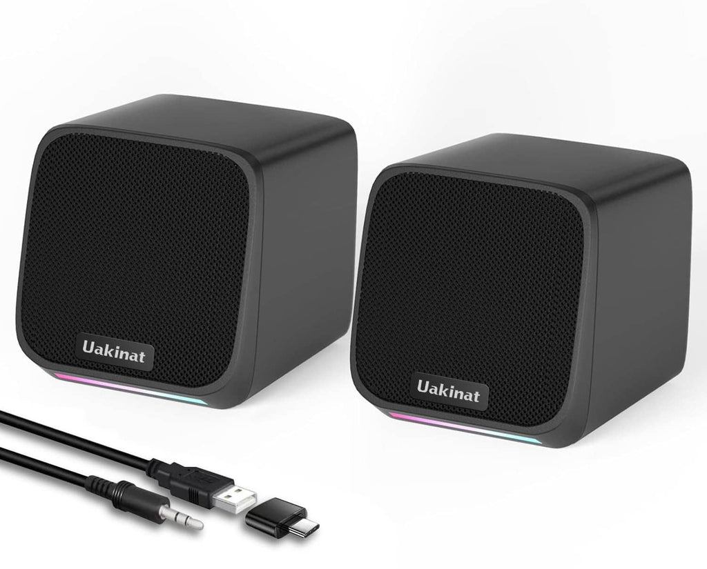 Pair of compact black desktop speakers with USB cable and 3.5mm adapter
