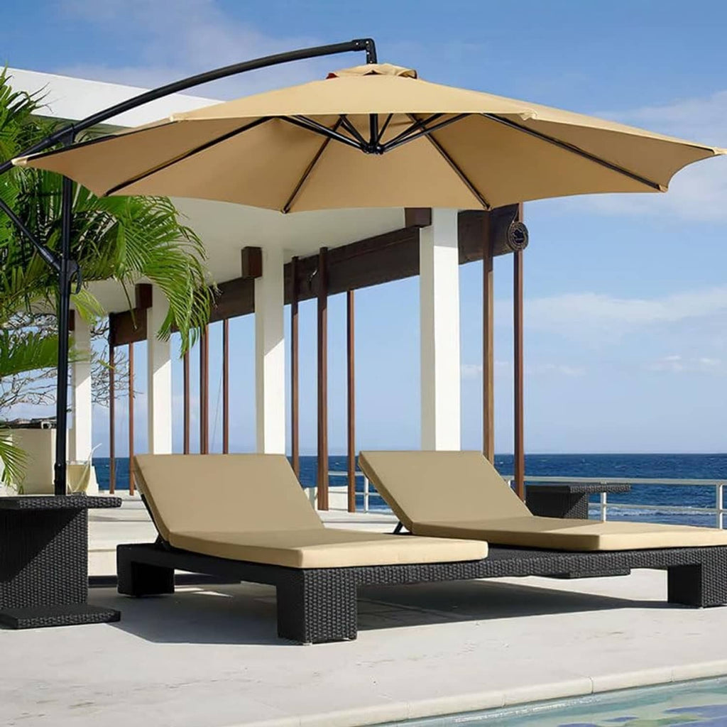 Tan patio umbrella canopy over outdoor lounge chairs