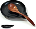Ceramic spoon rest with black leaf-shaped dish and brown wooden spoon handle