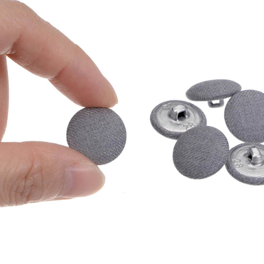 Grey fabric-covered button with metal shank, shown front and back detail