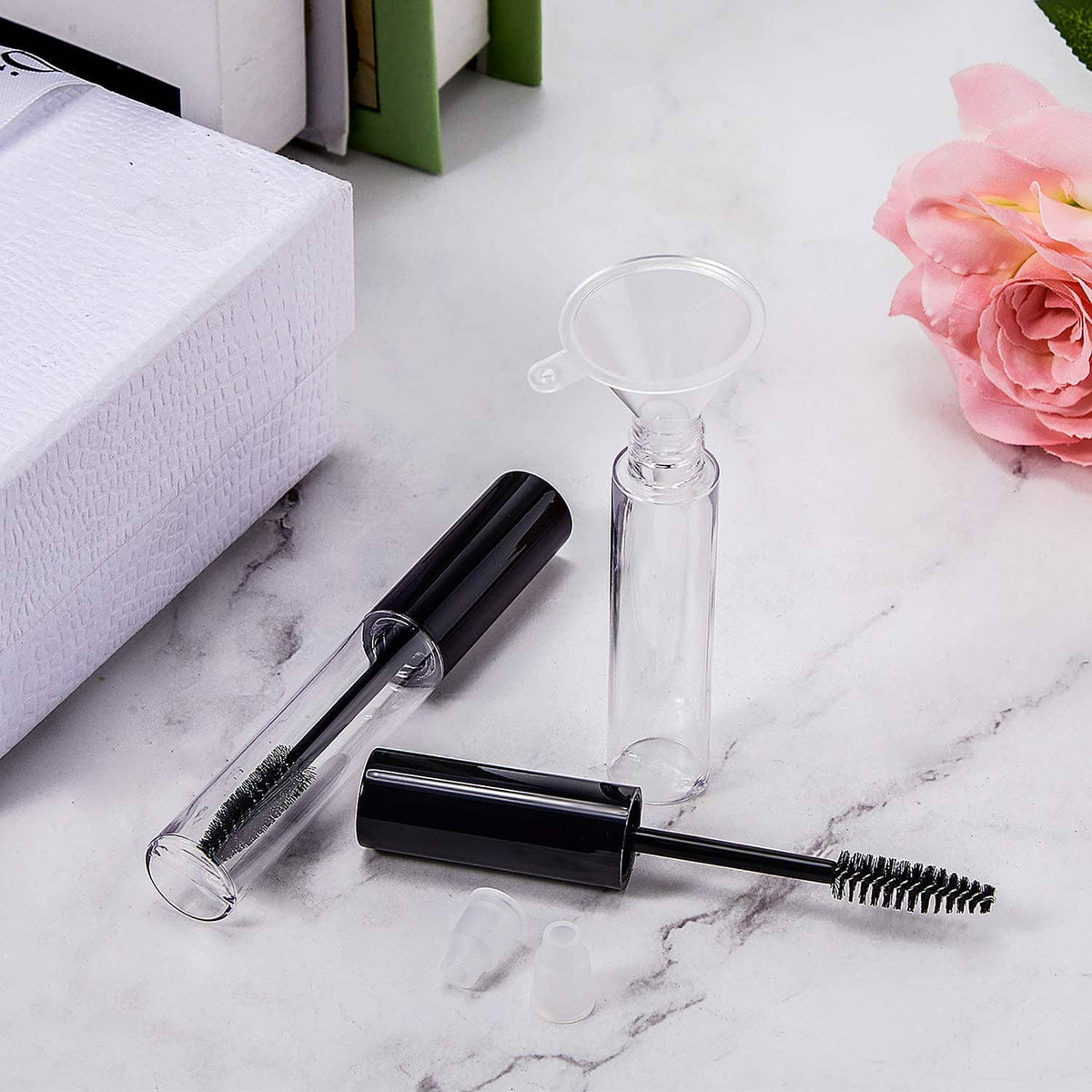 Clear empty mascara bottle with black cap and attached wand brush
