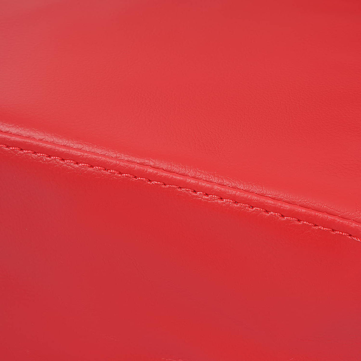 Close-up of red seat cover surface with stitched seam line