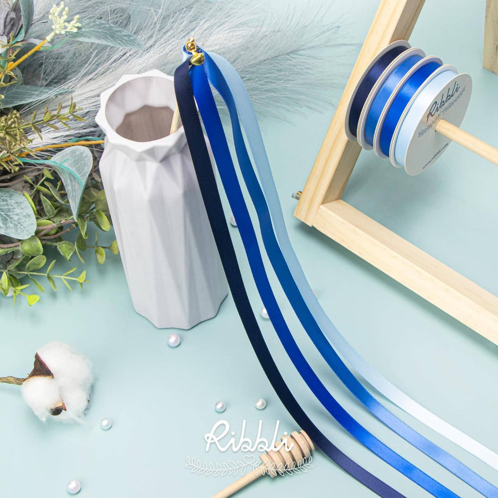 Blue satin ribbon strips on wooden dispenser, light blue and navy tones