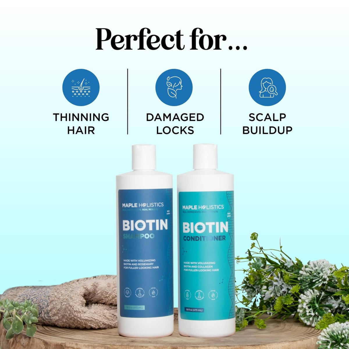 Biotin shampoo and conditioner bottles with green herbs on a wooden surface