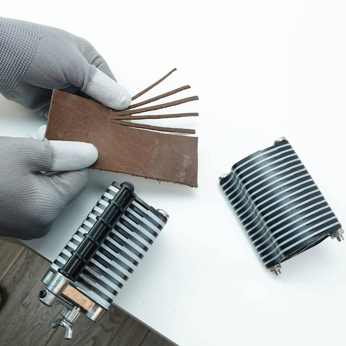Leather lace cutter assembling fringe strips; tan leather with blade and comb rollers