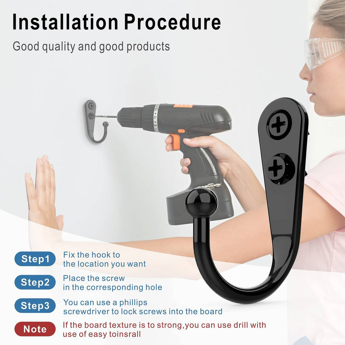 Black wall-mounted coat hook installed on a wall with driver drill