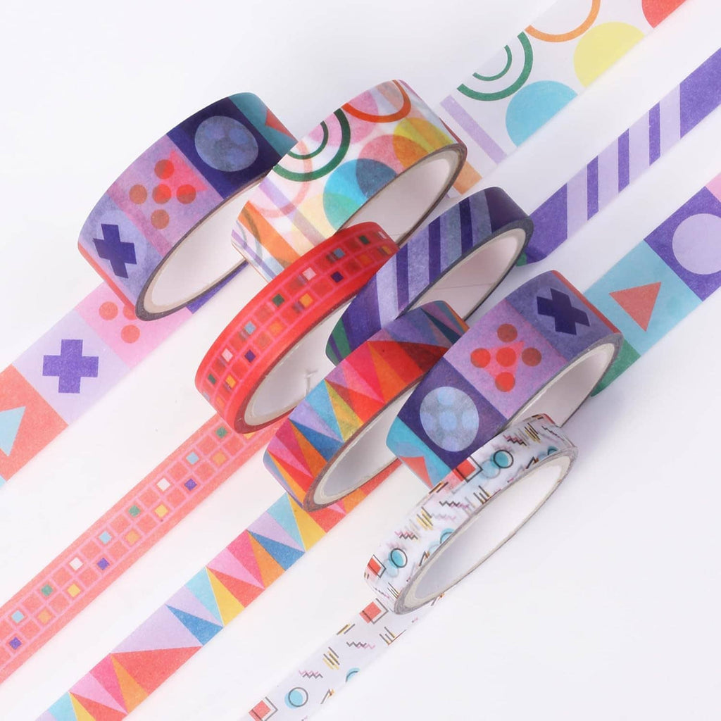 Assorted washi tape rolls with geometric patterns laid across a white tabletop