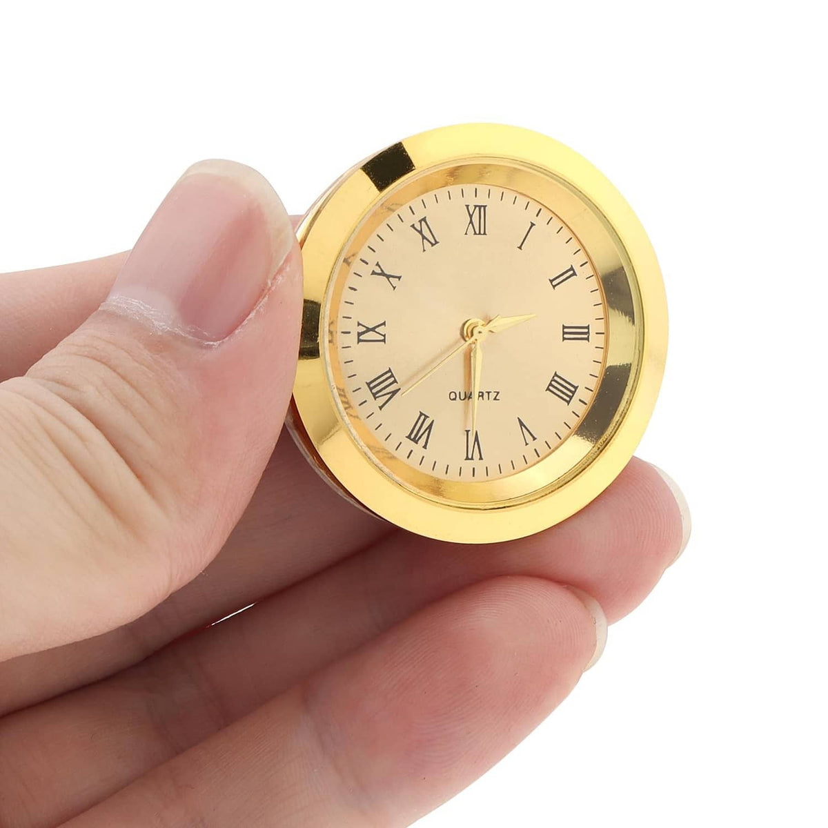 Mini quartz clock face in hand, gold case with Roman numeral dial