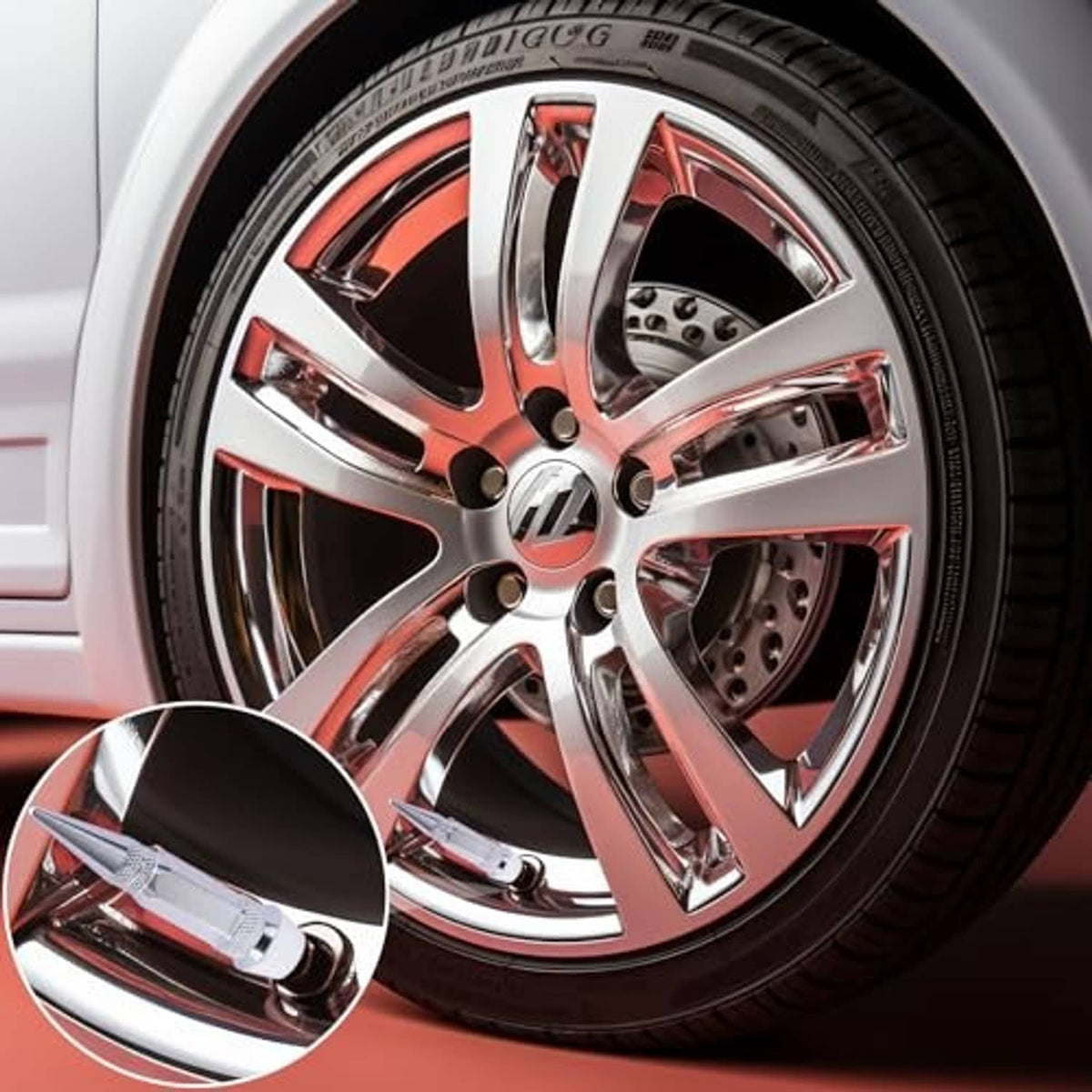 Spiked tire valve stem caps, silver, installed on a car wheel rim