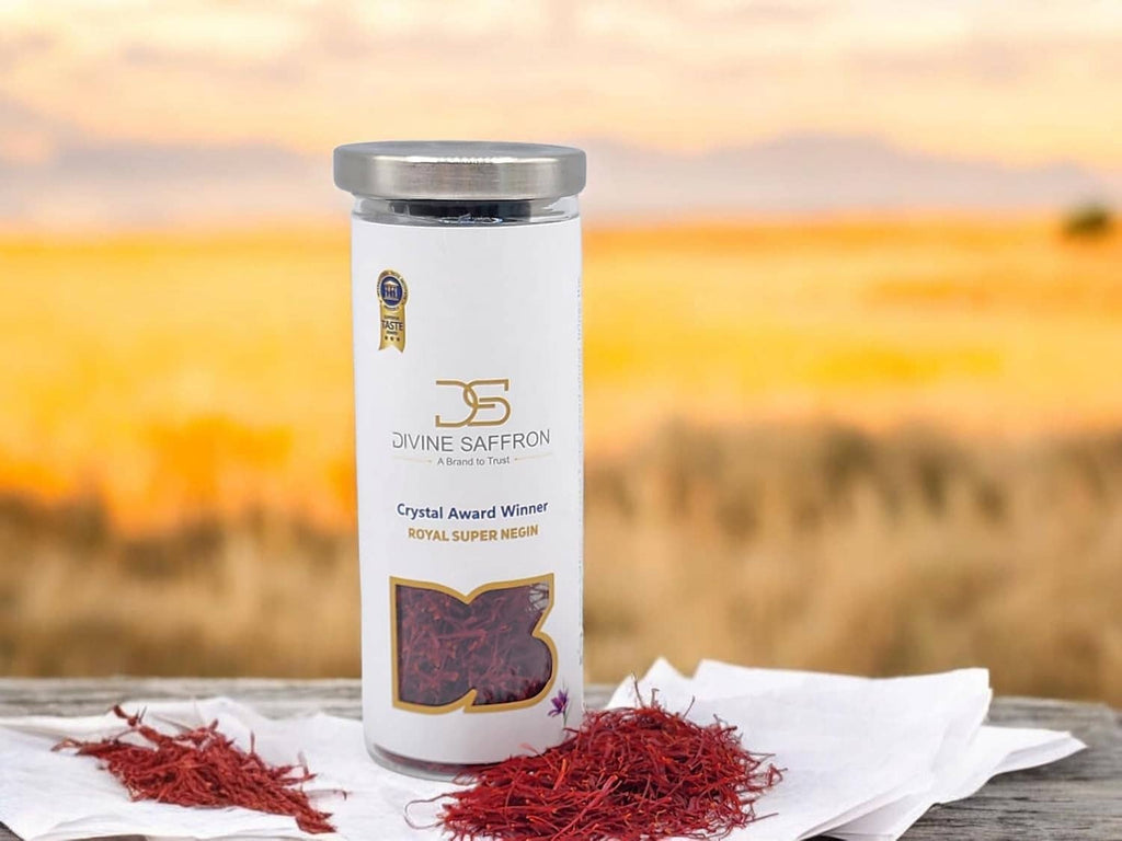 Saffron threads jar with silver lid and loose red threads on white paper