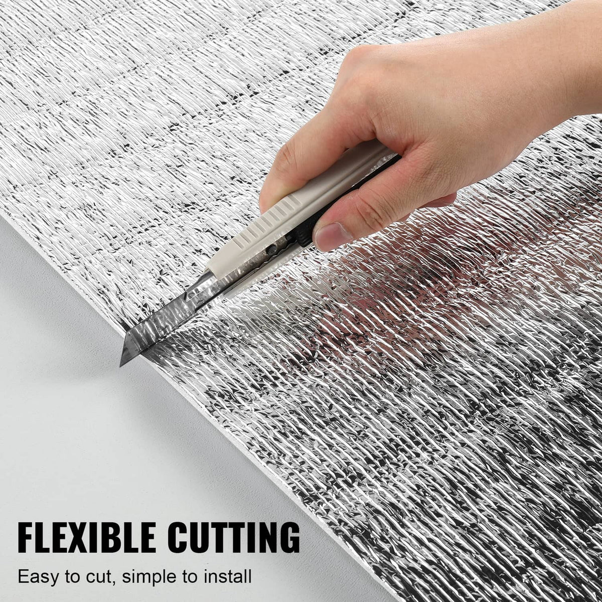 Reflective insulation roll being cut with a utility knife for easy installation