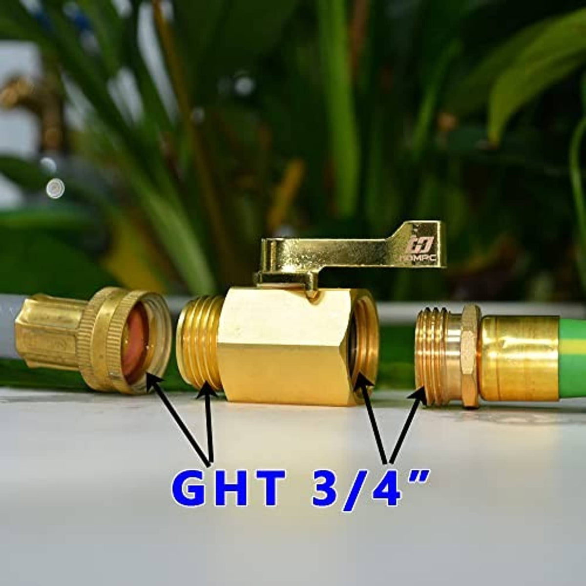 Brass garden hose shut-off valve mounted on a green garden hose with lever handle