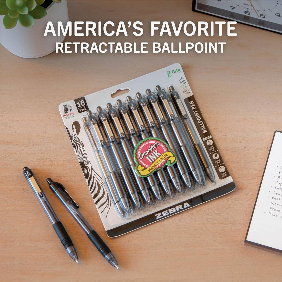 Retractable ballpoint pen set in blister, with black pens and one blue pen on desk.
