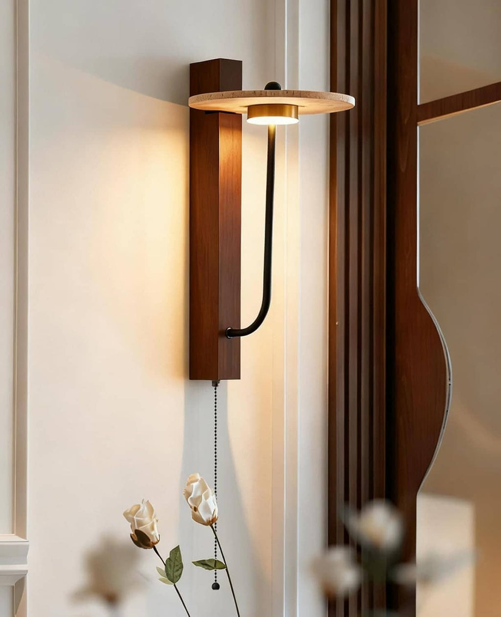 Wood wall sconce with round travertine shade and black curved arm, warm light on