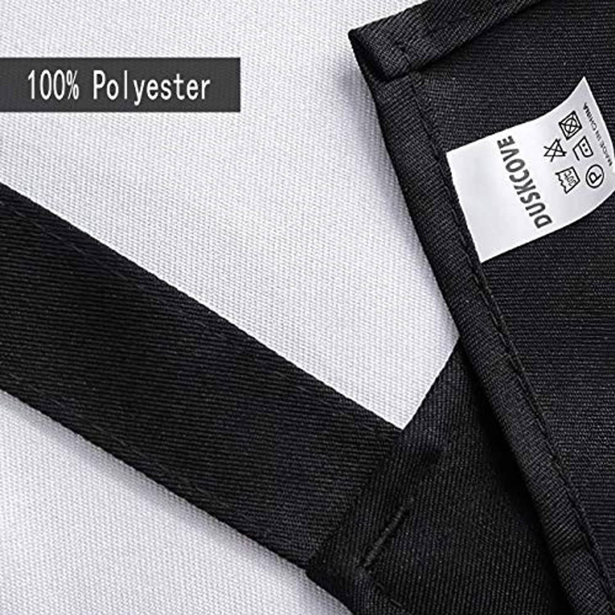 Black polyester apron fabric close-up with stitched edge and label detail