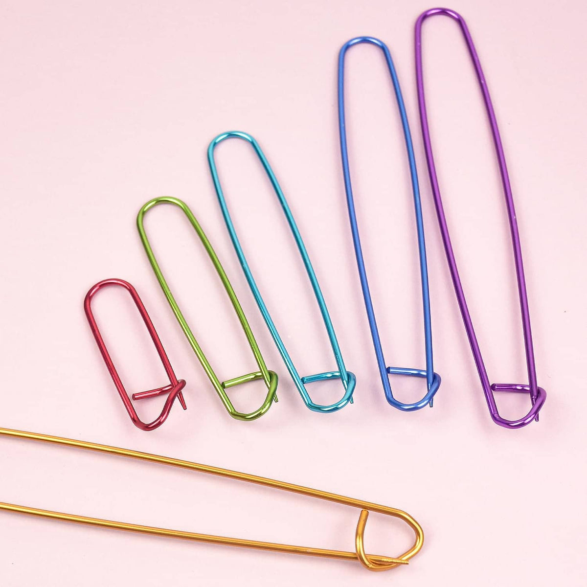 Colorful U-shaped knitting stitch markers arranged with overlapping metal loops