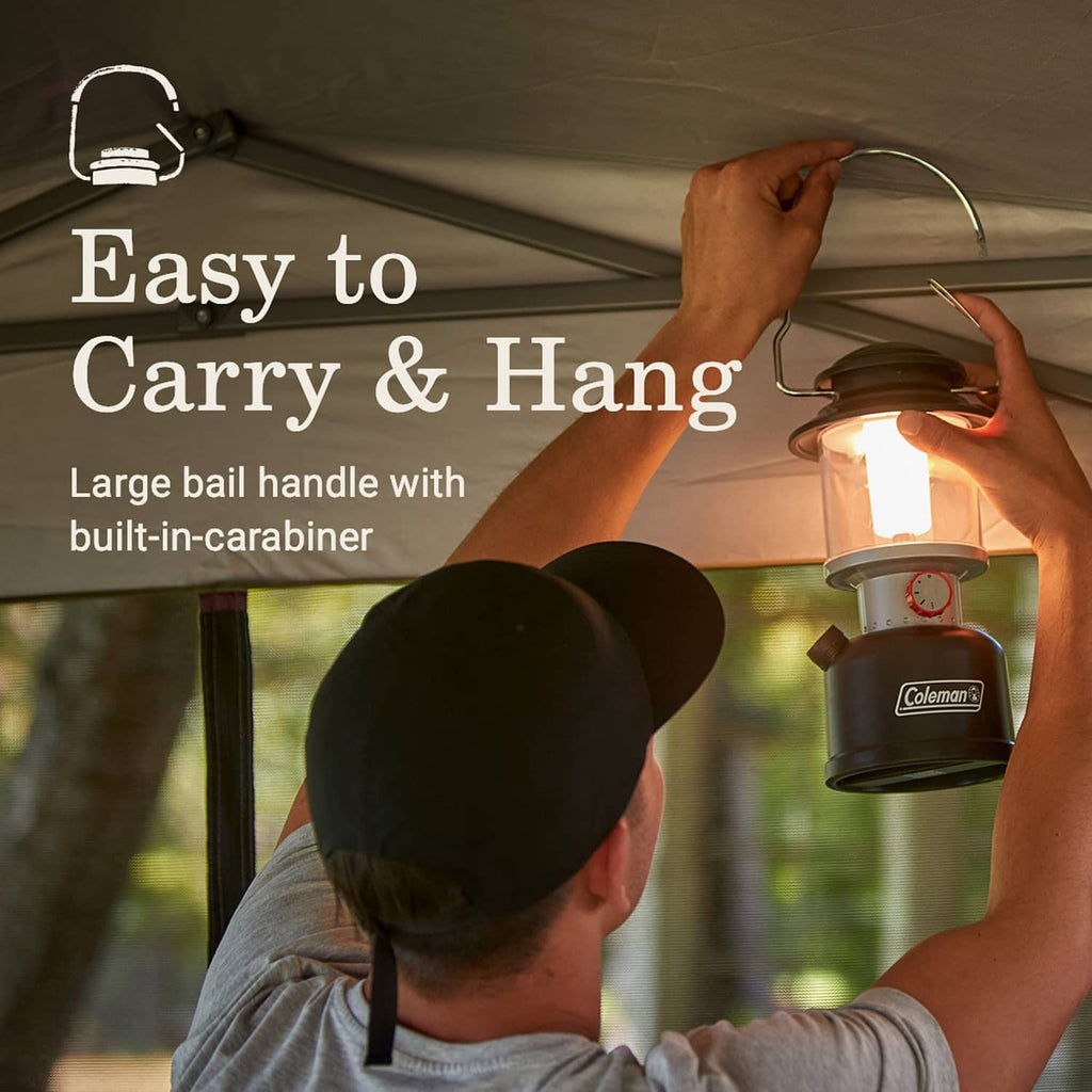 Black Coleman LED lantern with metal carry handle and glowing lamp head.