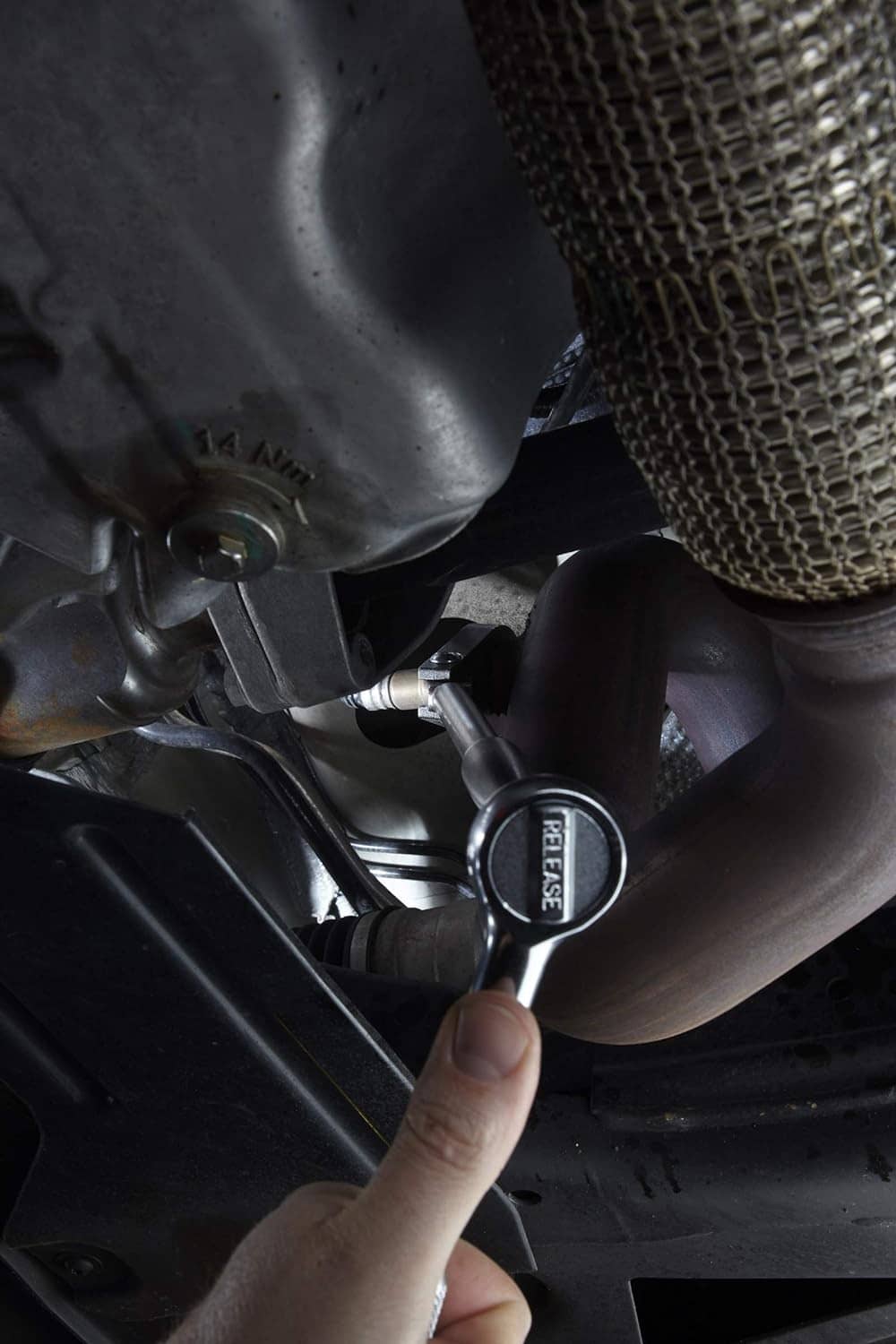 Brake drum puller in use: threaded center bolt with strap/chain attachment by wheel hub