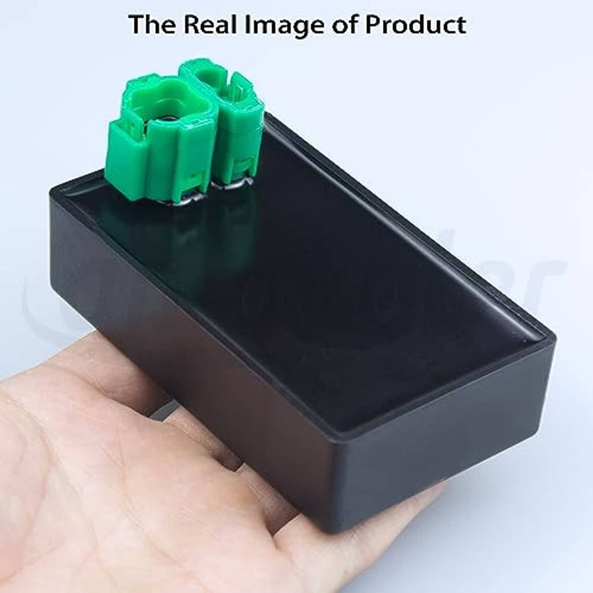 Ignition CDI module box held in hand, black case with green connector