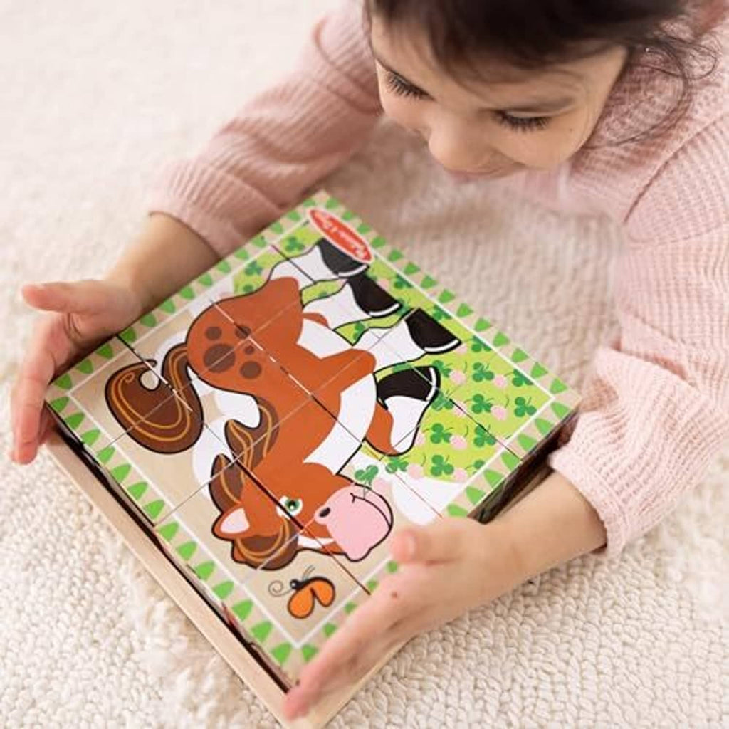 Child assembling a farm cube puzzle in a wooden tray with cow and dog pieces