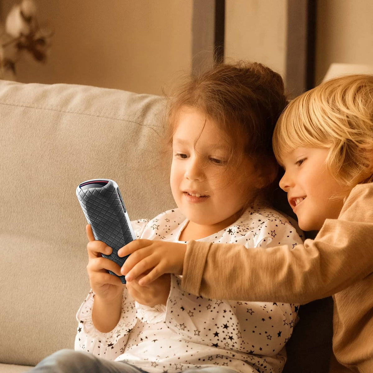Child holding a gray remote control cover, slim protective case for TV remote.