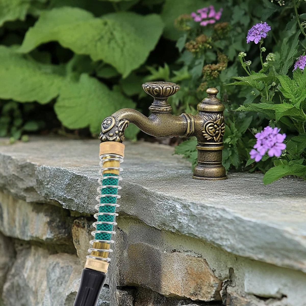 Brass hose protector with teal coil spring connected to outdoor spigot on stone wall