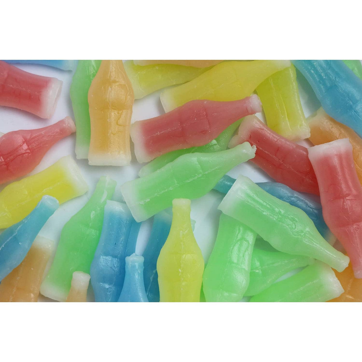 Close-up of wax bottle-shaped candies in green, yellow, blue, and pink