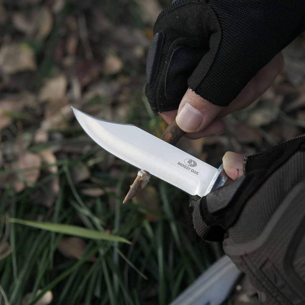 Hand holding a Bowie knife with wood handle and black sheath
