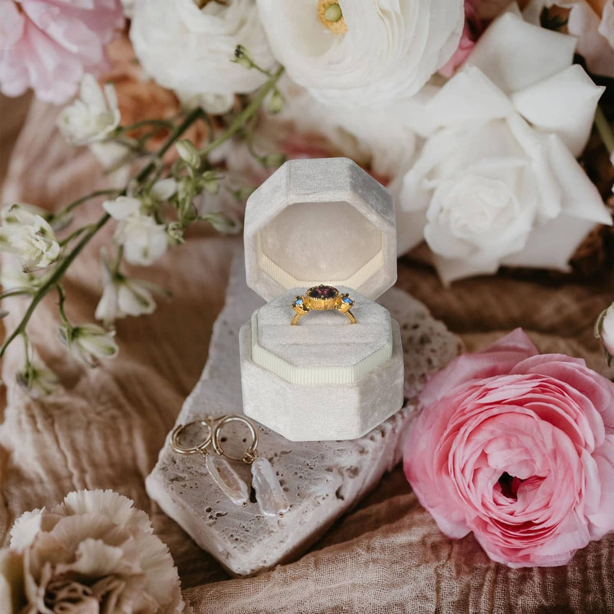 Beige octagon velvet ring box, open with ring placed on cushion
