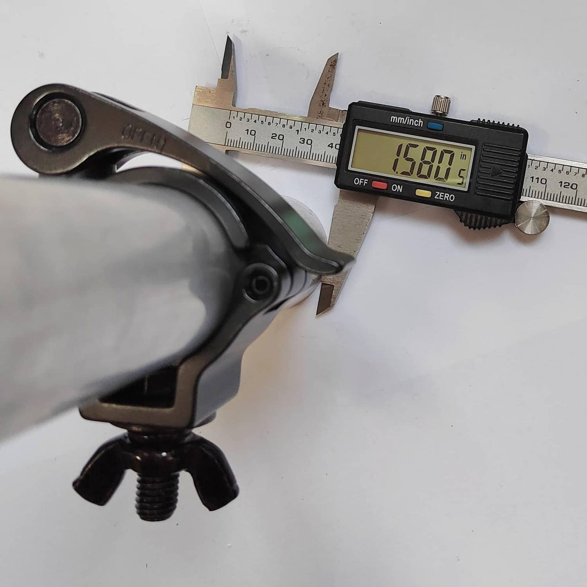 Black quick-release pipe clamp measured with calipers for pipe diameter fit