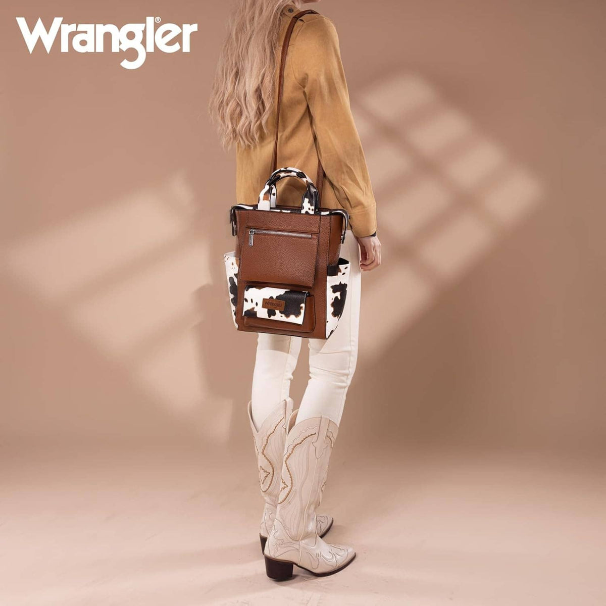 Cow-print vegan leather backpack purse with Wrangler patch, front zip pocket, top handles