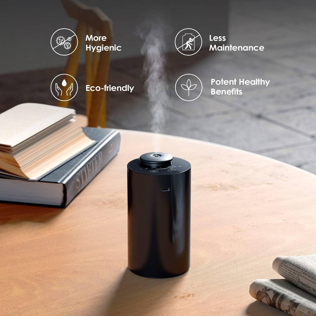 Black waterless essential oil diffuser on a wooden table near books