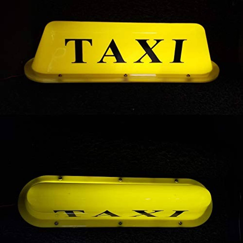 Yellow TAXI dome light with magnetic base, illuminated lettering on dark surface