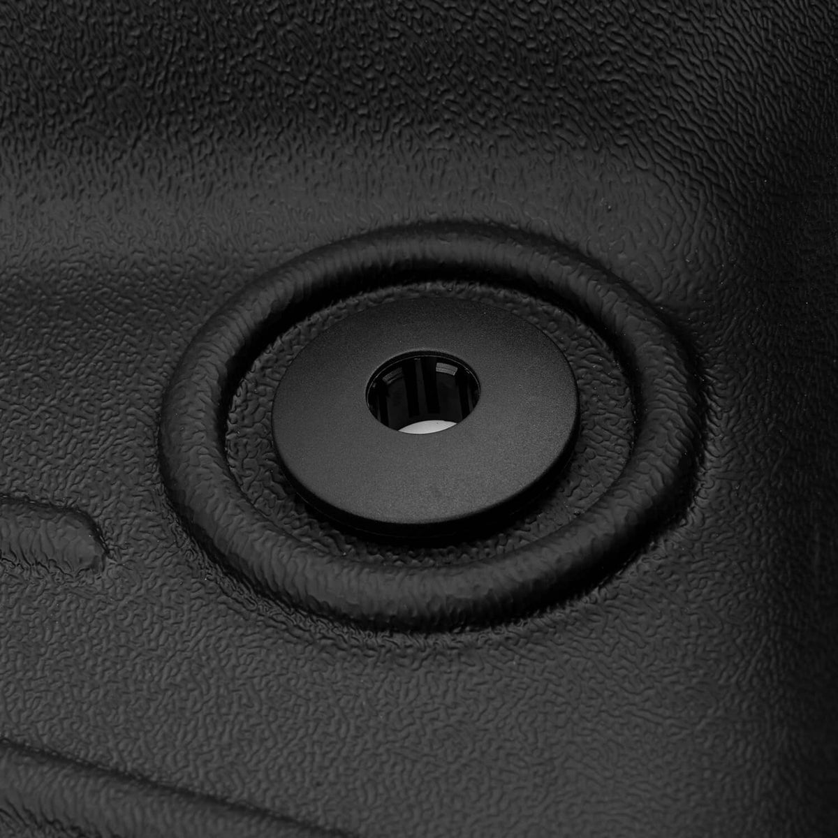 Close-up of black floor mat grommet with circular anchor hole