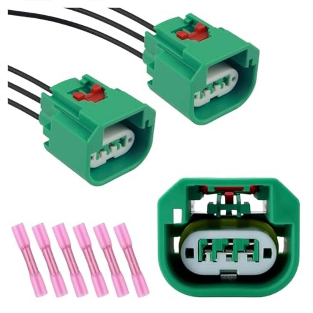 Green headlight wiring connectors with exposed terminal blocks, black wires, pink pins