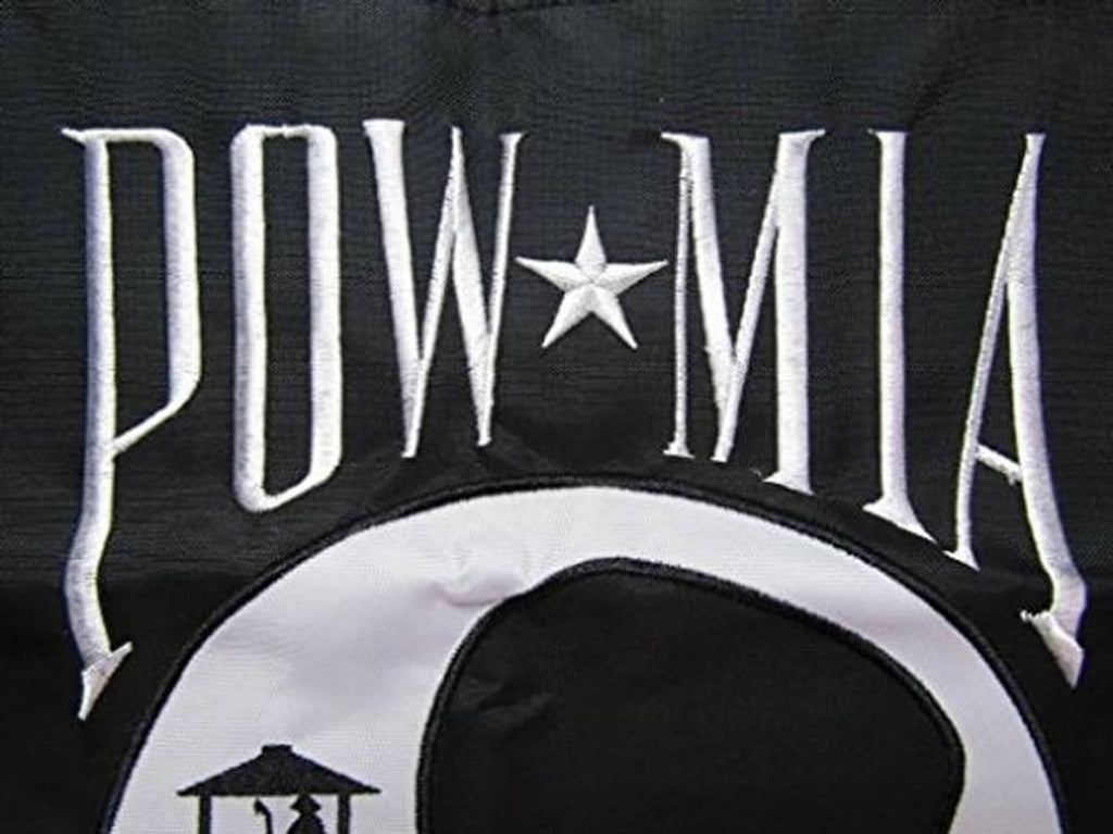Close-up of embroidered POW*MIA banner top text and star over white emblem