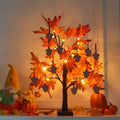 Orange fall maple leaf tree decoration with warm LED lights and dangling acorn ornaments