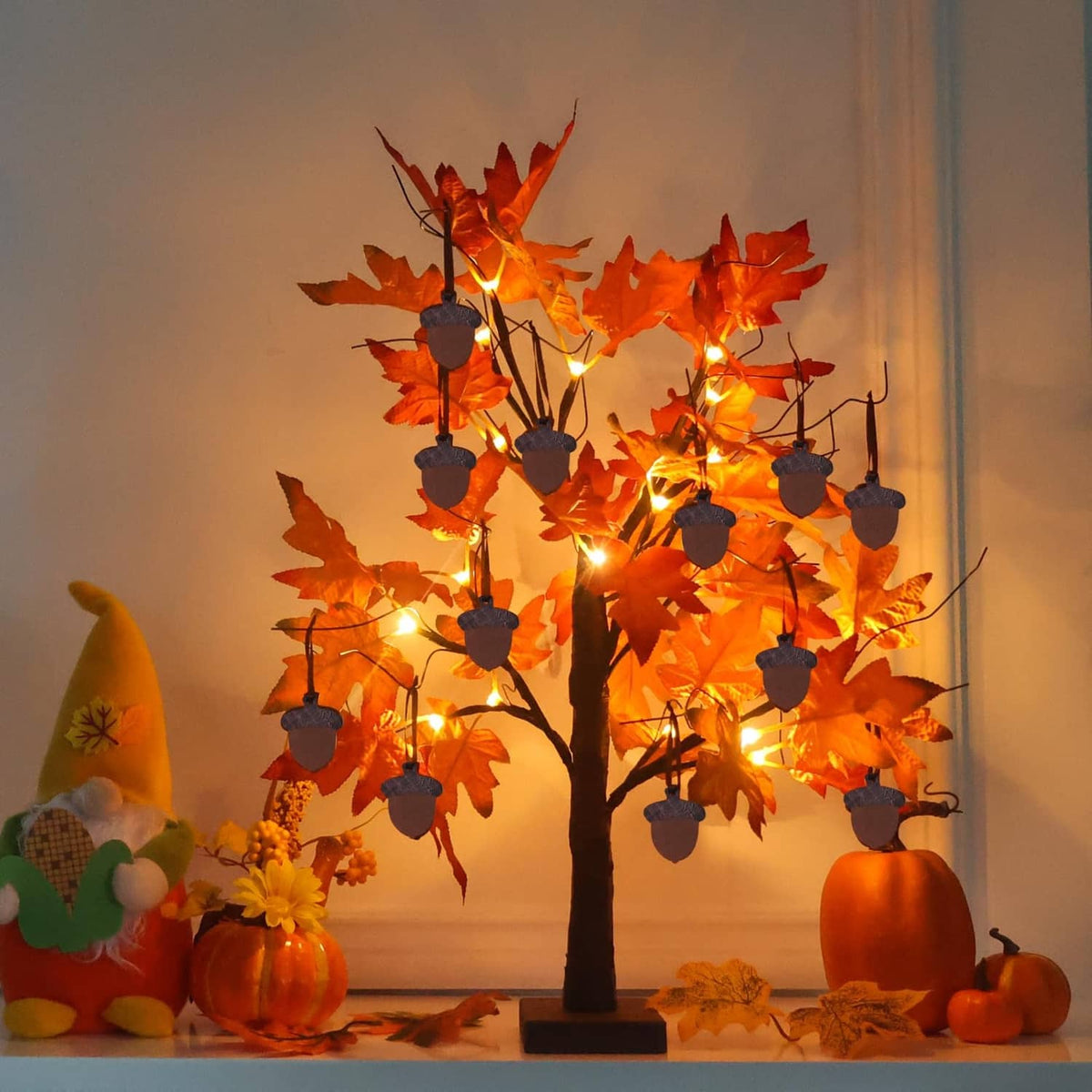 Orange fall maple leaf tree decoration with warm LED lights and dangling acorn ornaments