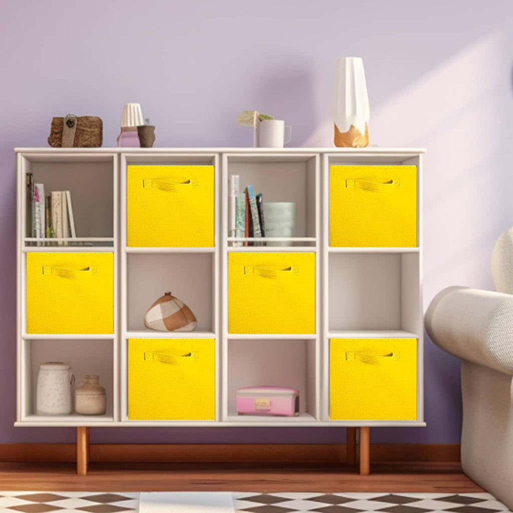 Multiple yellow fabric storage bins with handles in an open cabinet.
