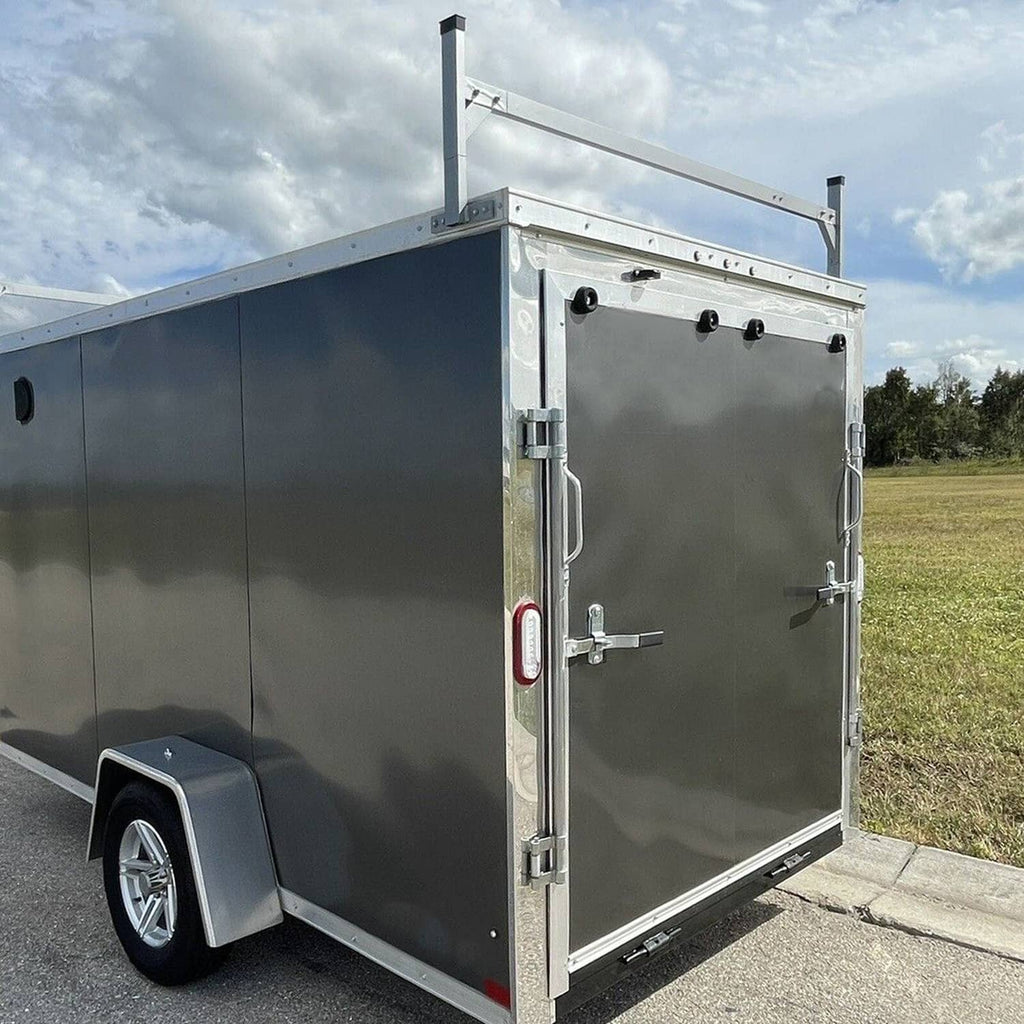 Side view of enclosed cargo trailer with installed roof mount ladder rack bracket, white steel