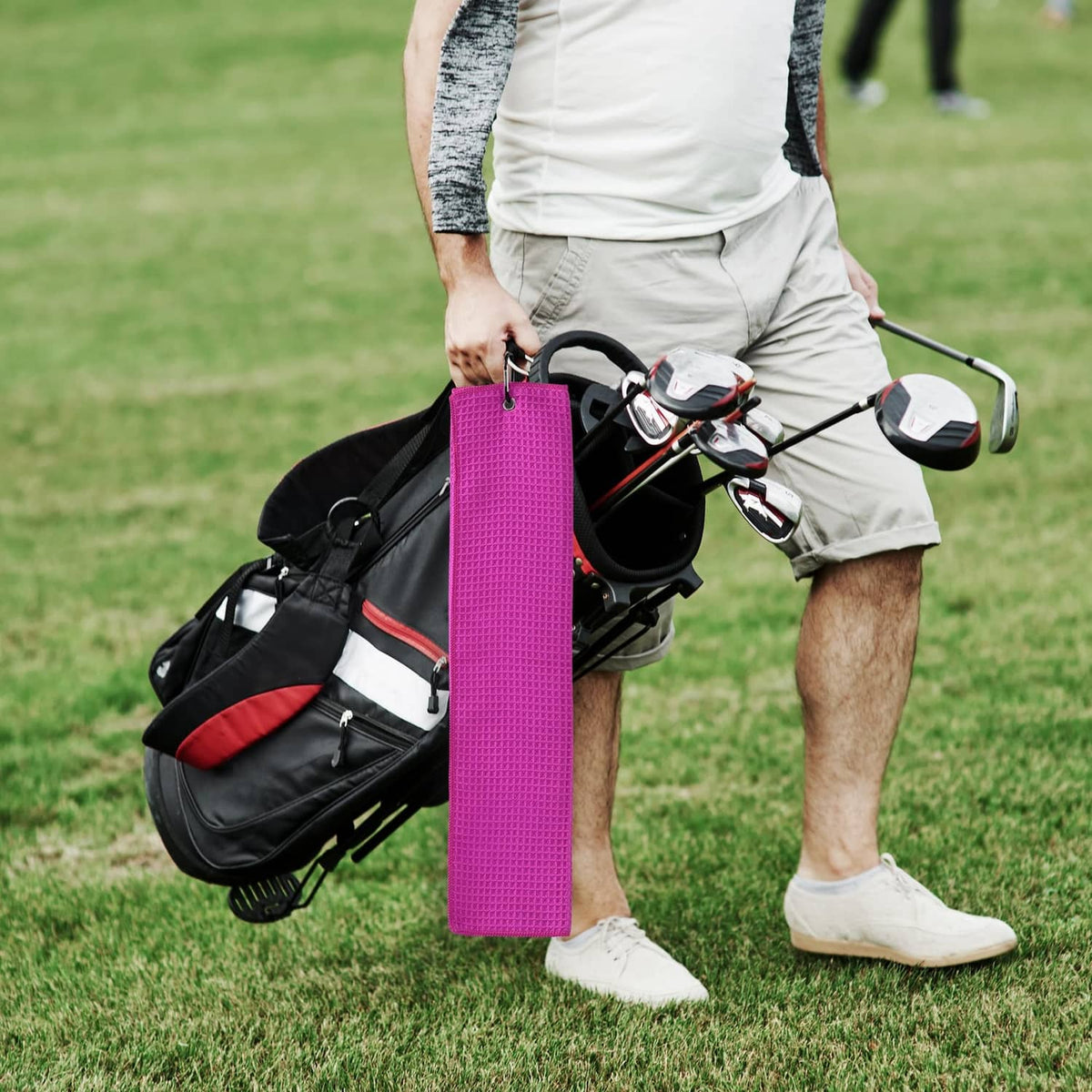 Magenta waffle-weave microfiber towel hanging from a golf bag clip