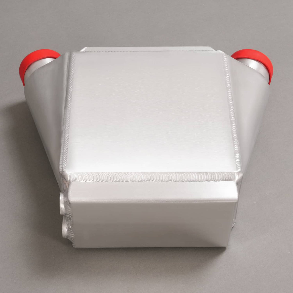 Aluminum intercooler, rear view with red end caps and welded cooling fins.