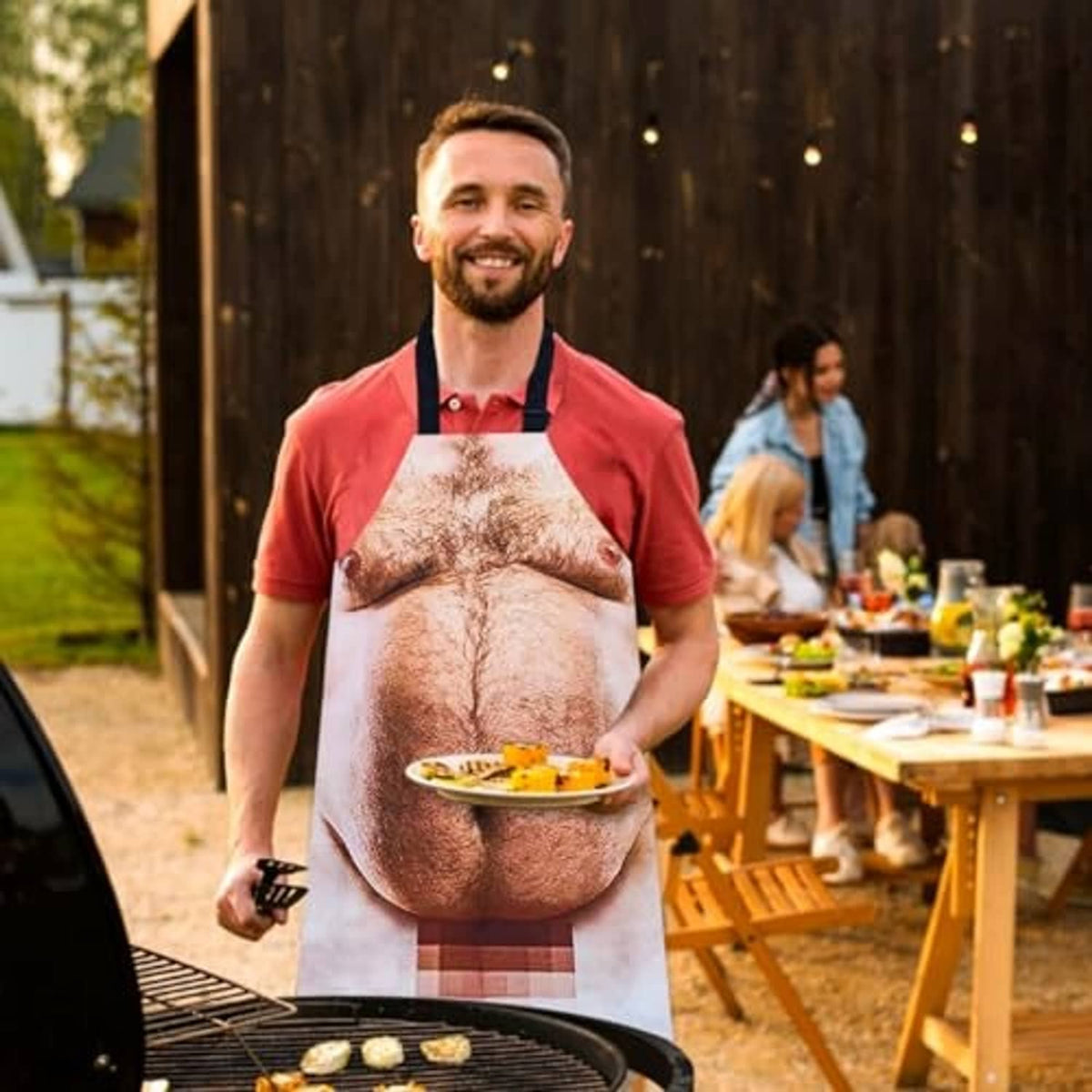 Funny novelty grilling apron worn while grilling outdoors, printed male torso design