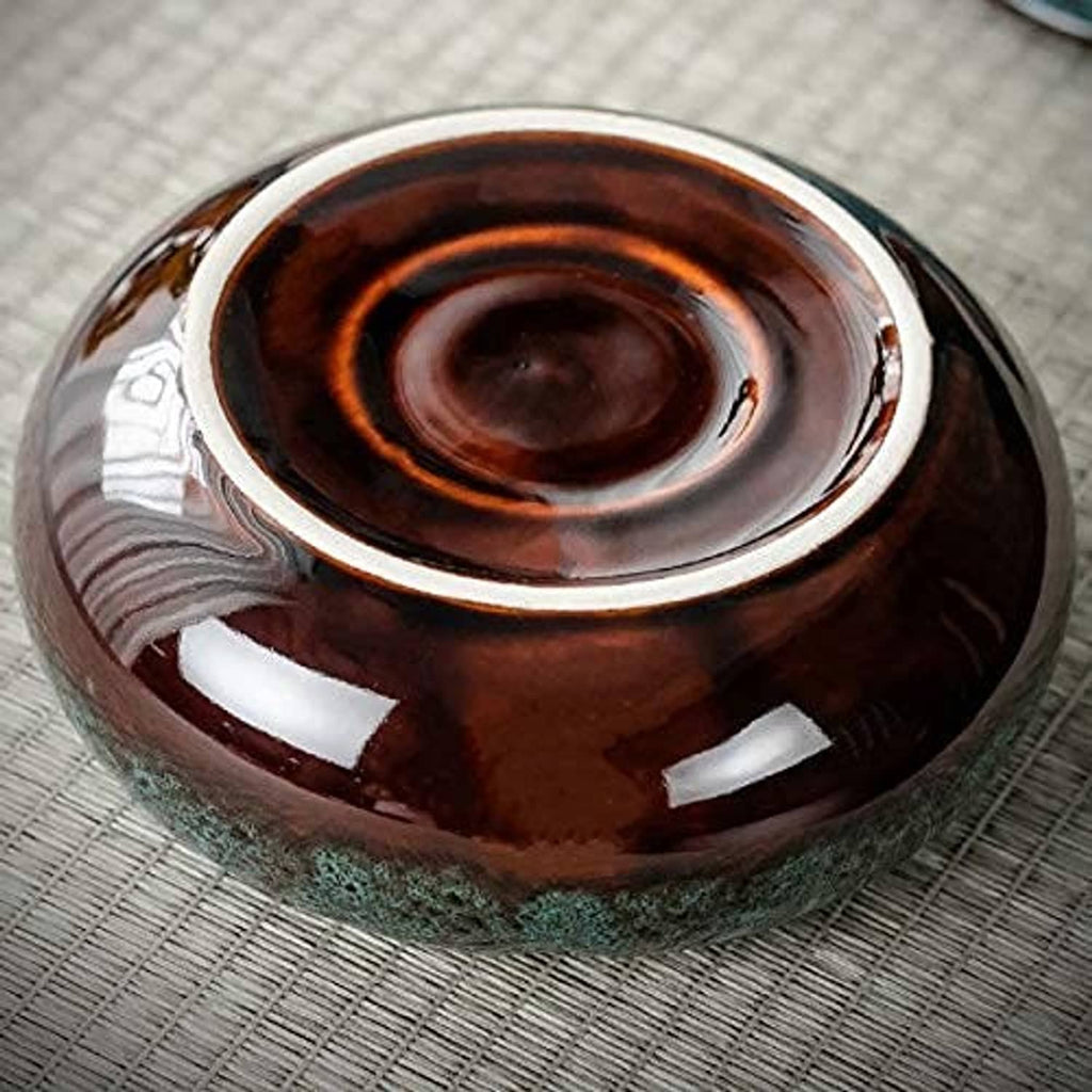 Round ceramic ashtray base with dark brown interior and white-edged rim, top view