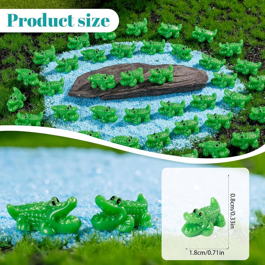 Green mini crocodile resin figurines on blue gravel with a dark rock base