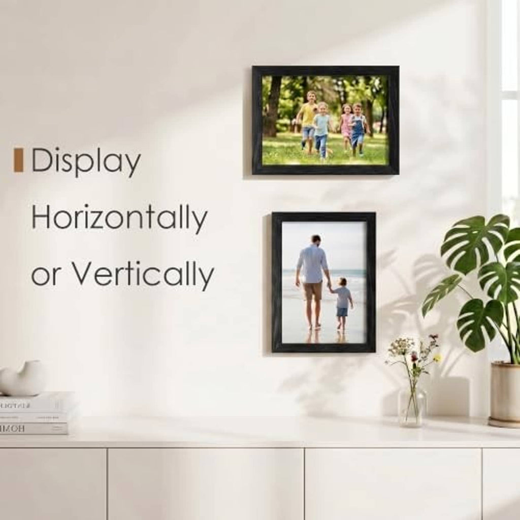 Black wood picture frame displaying a family photo on a light wall.