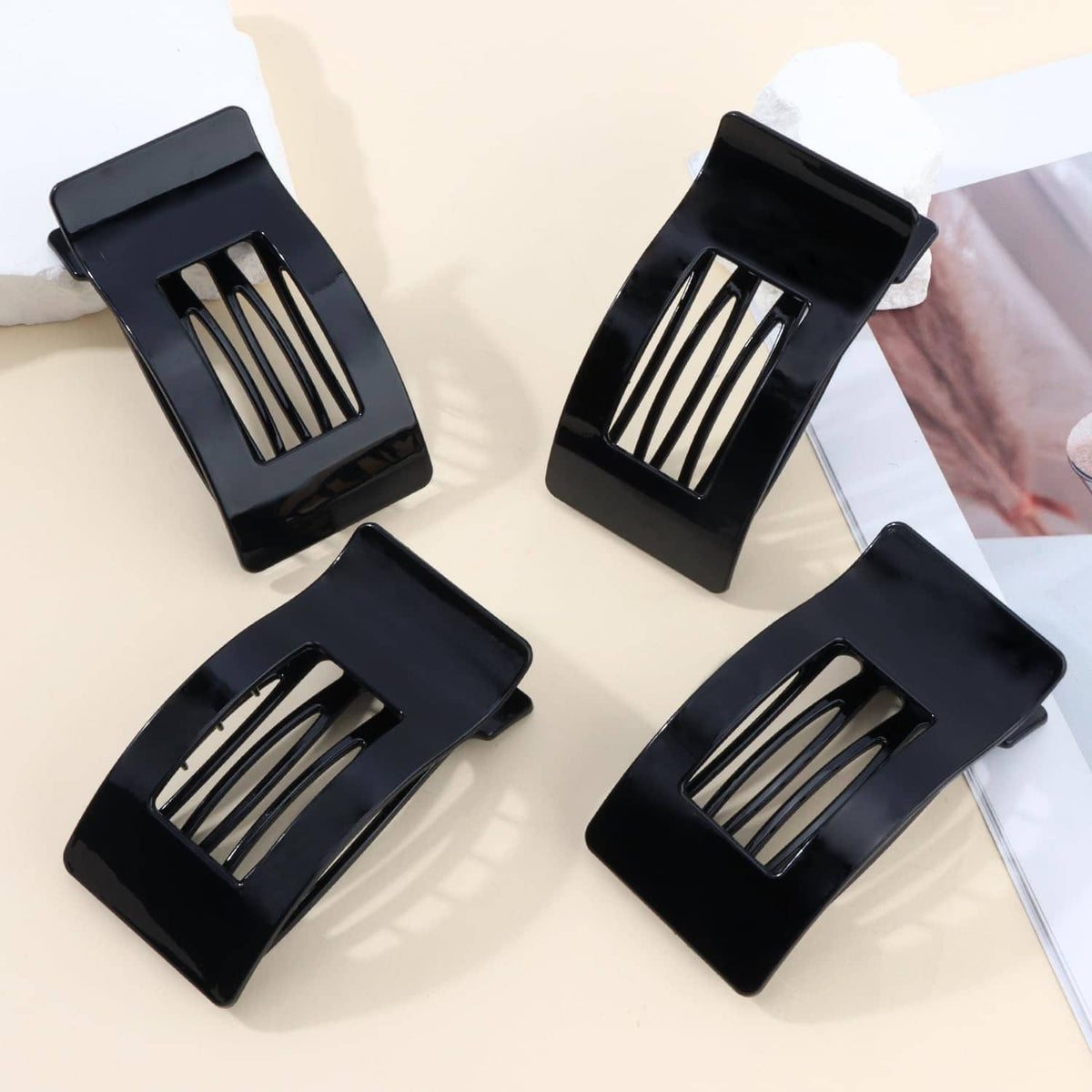 Four bright black flat hair clips with comb teeth, rectangular openings