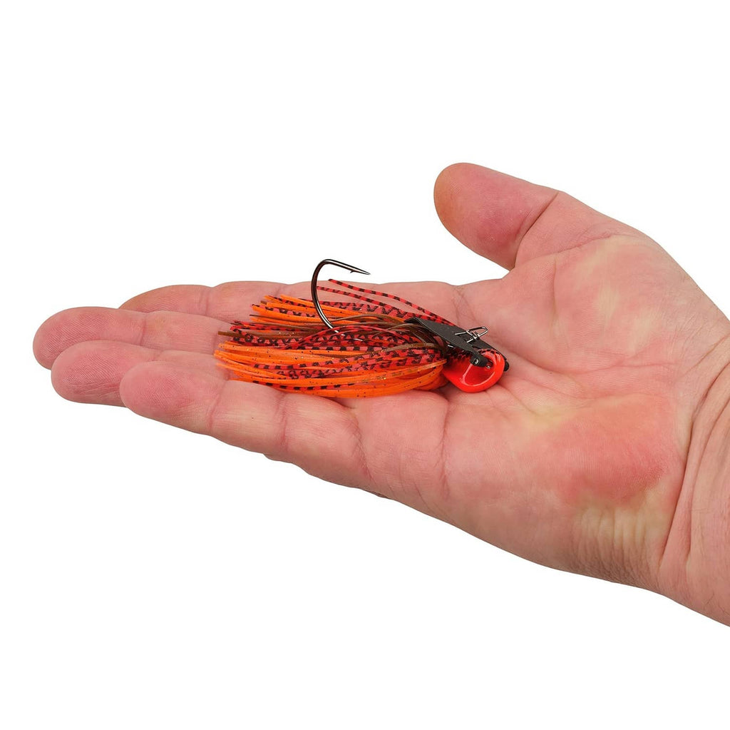 Orange bladed fishing jig shown in a hand, with black blade and silicone skirt.