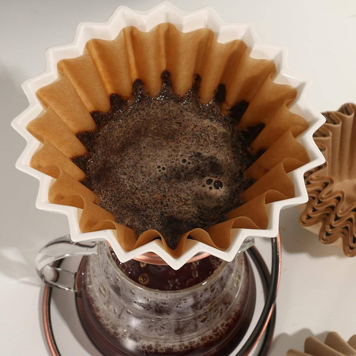 Natural coffee filter holding dark brewed coffee with foamy top